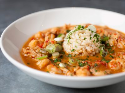 bowl of crawfish etouffe with scoop or white rice